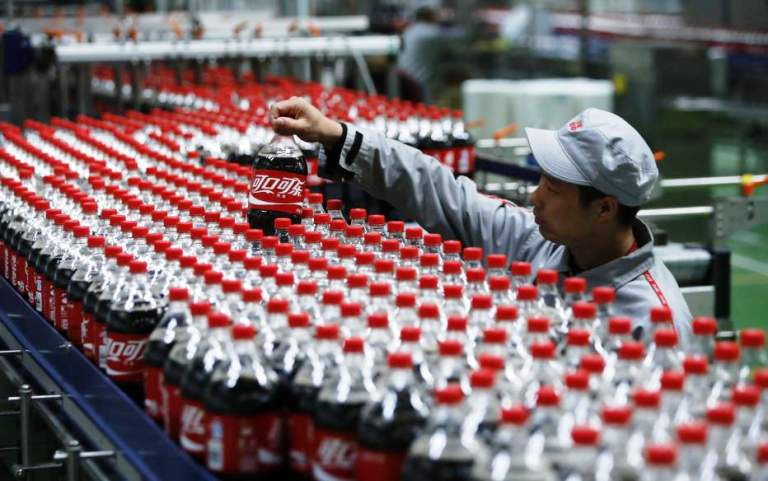 Zisk nápojového gigantu Coca-Cola klesl téměř o třetinu